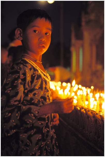 enfant allumant bougie à la shwedagon au Myanmar