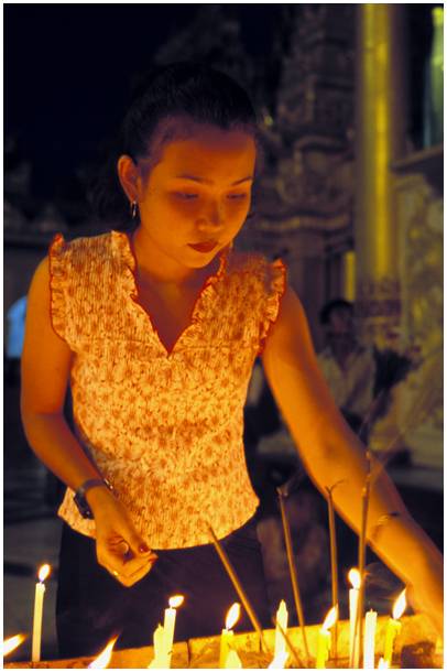 jeune femme allumant des bougies  la pagode Shwedagon au Myanmar